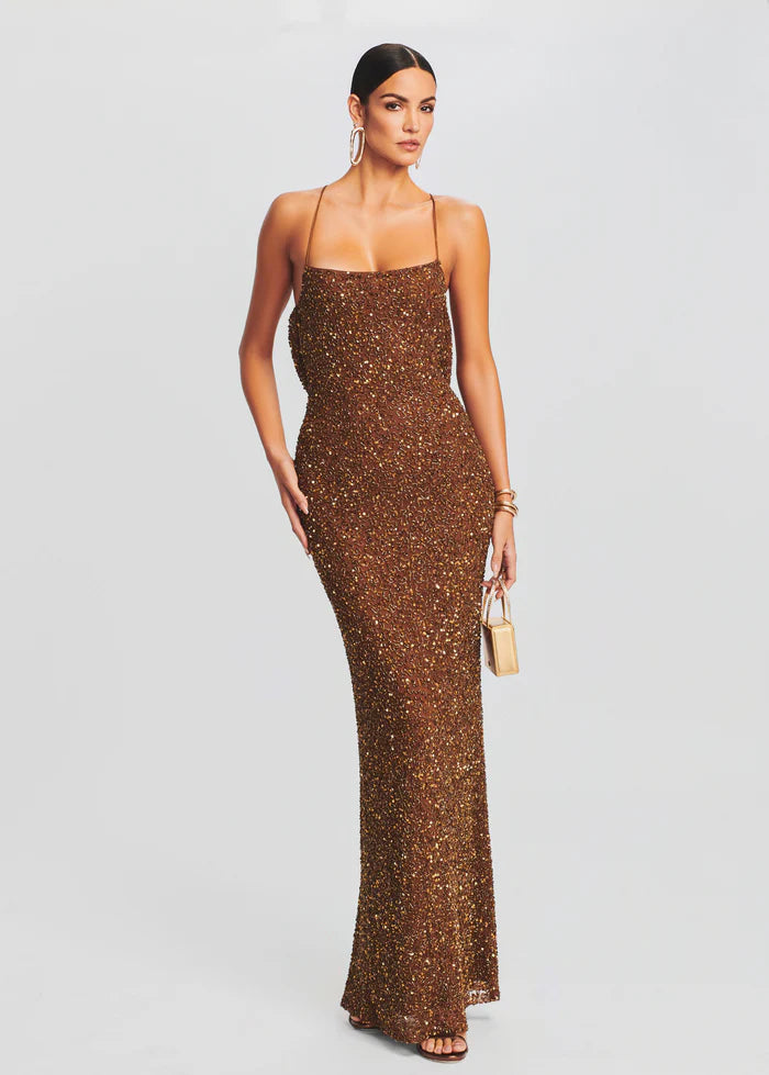 Woman wearing bronze sequin evening gown with straight neckline and thin straps holding small beige handbag — Retrofete | Endless UAE