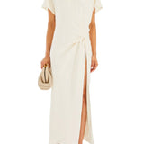 Woman wearing cream Tropez Maxi Dress with side slit, straw bag and strappy heels — SER.O.YA | Endless UAE