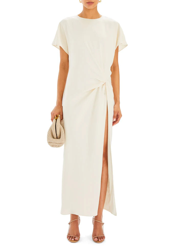 Woman wearing cream Tropez Maxi Dress with side slit, straw bag and strappy heels — SER.O.YA | Endless UAE