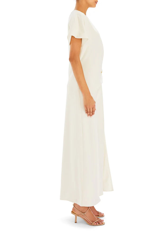 Woman wearing cream Tropez Maxi Dress with side slit, straw bag and strappy heels — SER.O.YA | Endless UAE