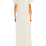 Woman wearing cream Tropez Maxi Dress with side slit, straw bag and strappy heels — SER.O.YA | Endless UAE