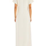 Woman wearing cream Tropez Maxi Dress with side slit, straw bag and strappy heels — SER.O.YA | Endless UAE