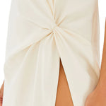 Woman wearing cream Tropez Maxi Dress with side slit, straw bag and strappy heels — SER.O.YA | Endless UAE