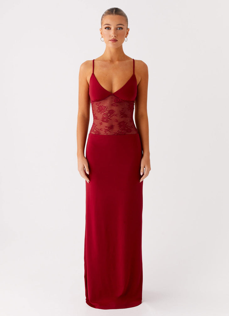 Woman wearing a red maxi dress with lace panel detail and thin straps against a light background — Peppermayo | Endless UAE