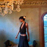 Elegant black halter top and navy skirt set worn by model in luxurious room with chandelier — With Jean | Endless UAE