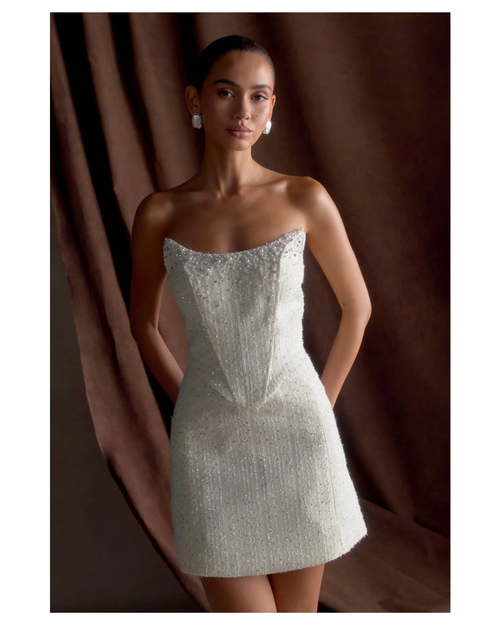 Woman wearing white strapless tweed corset mini dress against black background — Meshki | Endless UAE