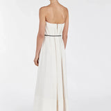 Back view of woman wearing cream strapless midi dress with black waist belt and sandals on white background — Dissh | Endless UAE