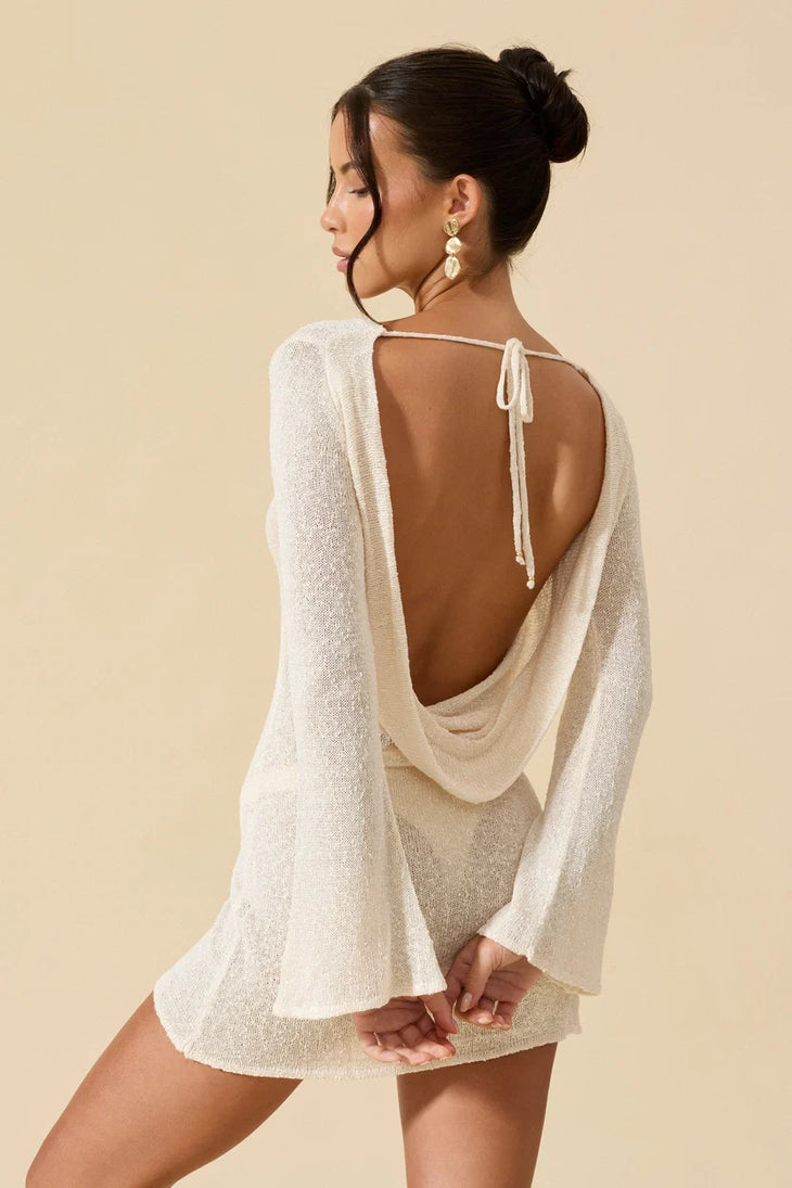 Woman wearing cream knit mini dress with long sleeves and flared cuffs — Flook The Label | Endless UAE
