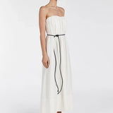 Woman wearing strapless cream marle midi dress with black tie belt and black sandals on white background — Dissh | Endless UAE