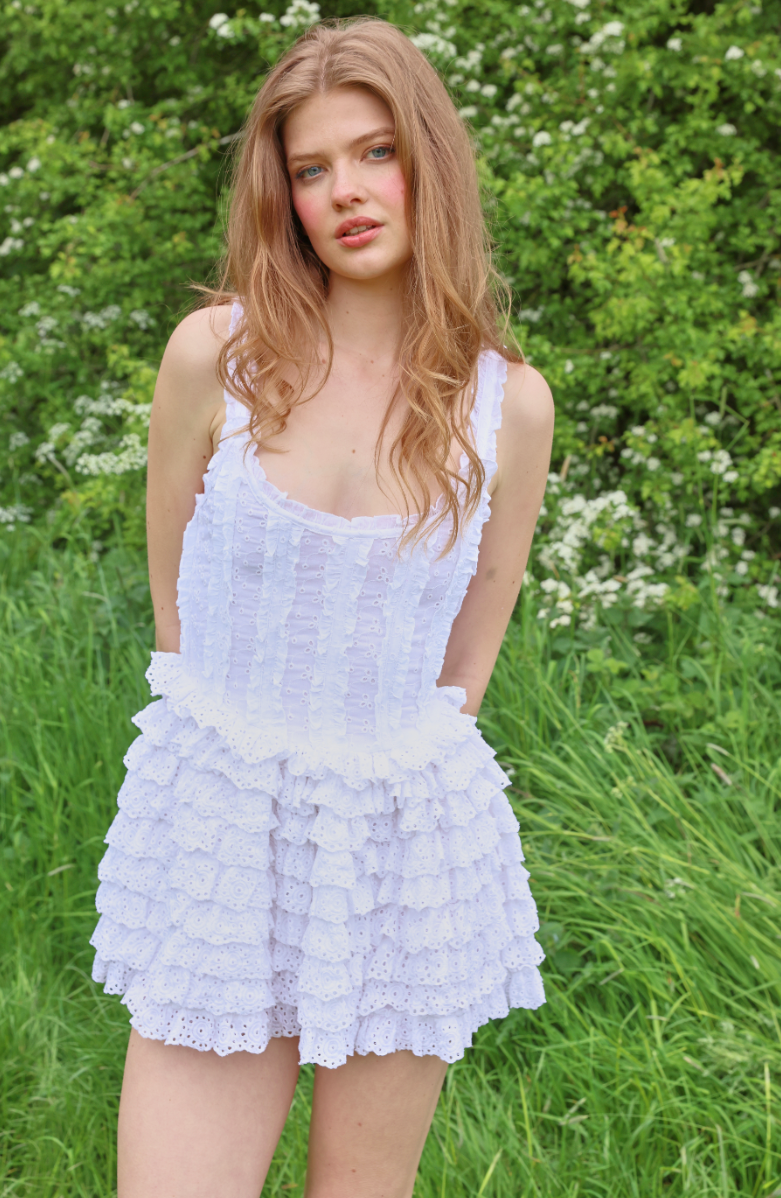 Lavender broderie anglaise mini dress with ruffle tiers and structured bodice worn in garden setting — Amy Jane London | Endless UAE