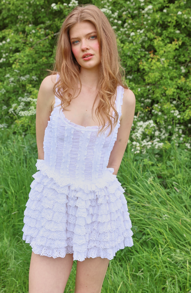 Lavender broderie anglaise mini dress with ruffle tiers and structured bodice worn in garden setting — Amy Jane London | Endless UAE