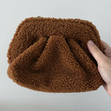 Gea Clutch in caramel brown textured fabric held in hand — TheMoire | Endless UAE