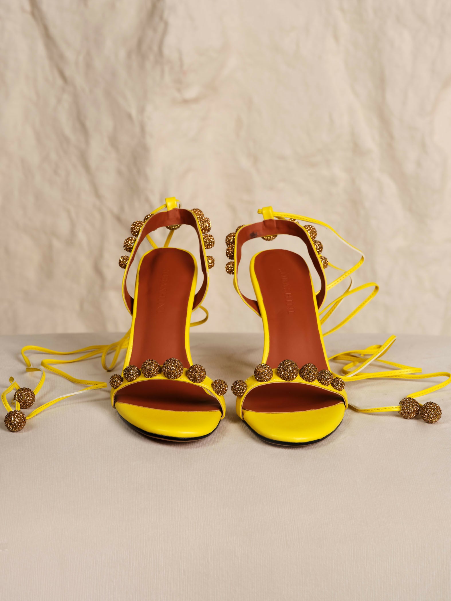 Bright yellow strappy heeled sandals with bronze embellished details and ankle tie closures — Subashini Heels | Endless UAE