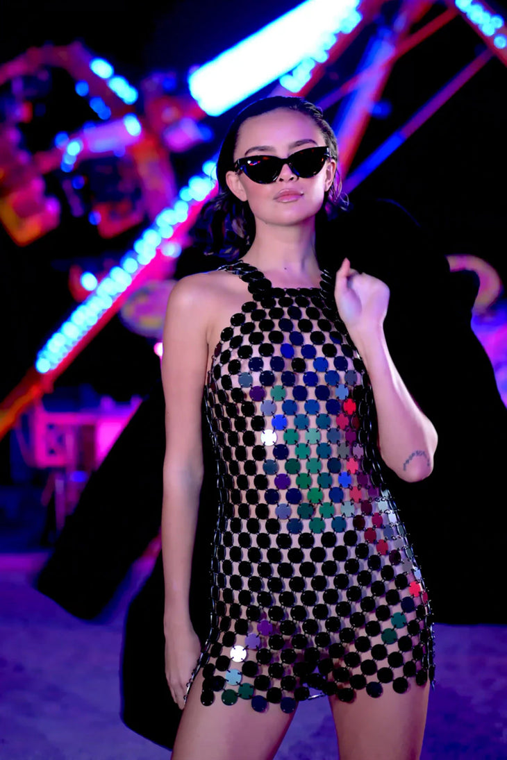 Woman wearing sequined halter dress with colorful circular paillettes under neon lights — Isabel Moore | Endless UAE
