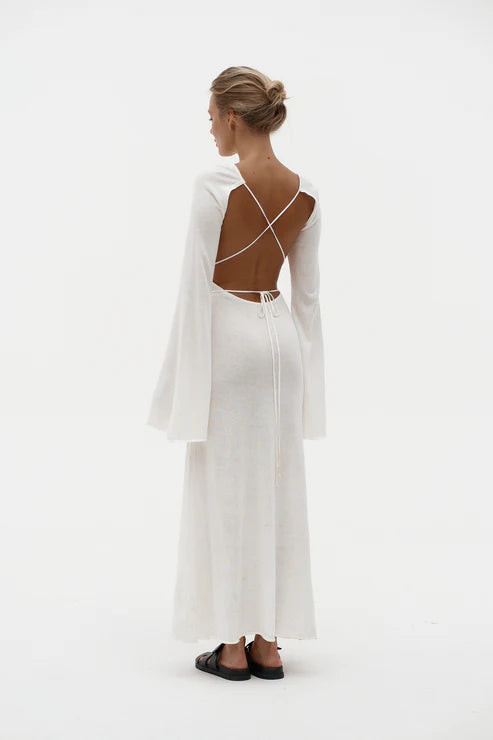 Woman wearing elegant white knit maxi dress with flared sleeves against minimal background — Affluence | Endless UAE