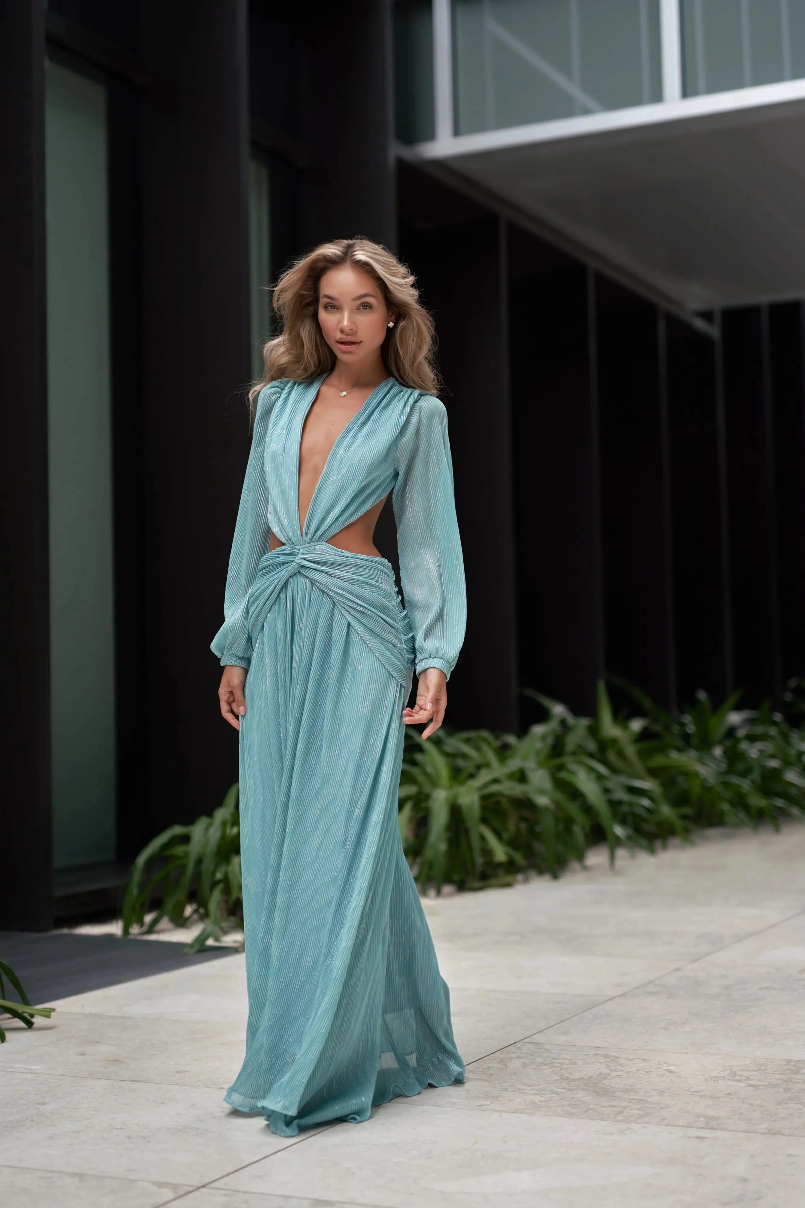 Woman wearing a flowing light blue wrap dress with long sleeves and cutout waist detail — Anne Louise Boutique | Endless UAE