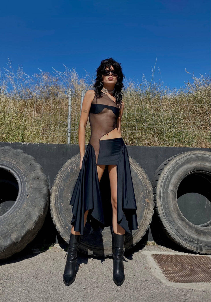 Woman wearing black mesh cut out dress with asymmetrical neckline and draped skirt — Sketch-Y | Endless UAE