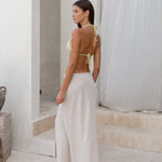 Woman wearing white linen Verona Maxi Skirt with yellow bikini top in minimalist setting — Beach City | Endless UAE