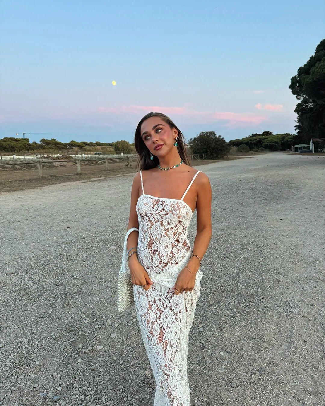 White lace camisole maxi dress styled with accessories in a desert setting — Scorpio Rizing | Endless UAE