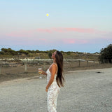 White lace camisole maxi dress styled with accessories in a desert setting — Scorpio Rizing | Endless UAE