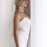 Elegant strapless white bridal gown with draped bodice and pearl drop earrings — You&I Bridal | Endless UAE