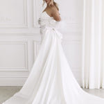 Elegant strapless white wedding gown with dramatic bow detail and flowing train — You&I Bridal | Endless UAE