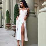 Elegant white midi dress with sweetheart neckline and high slit, modeled in classical architectural setting — Post Meridien | Endless UAE