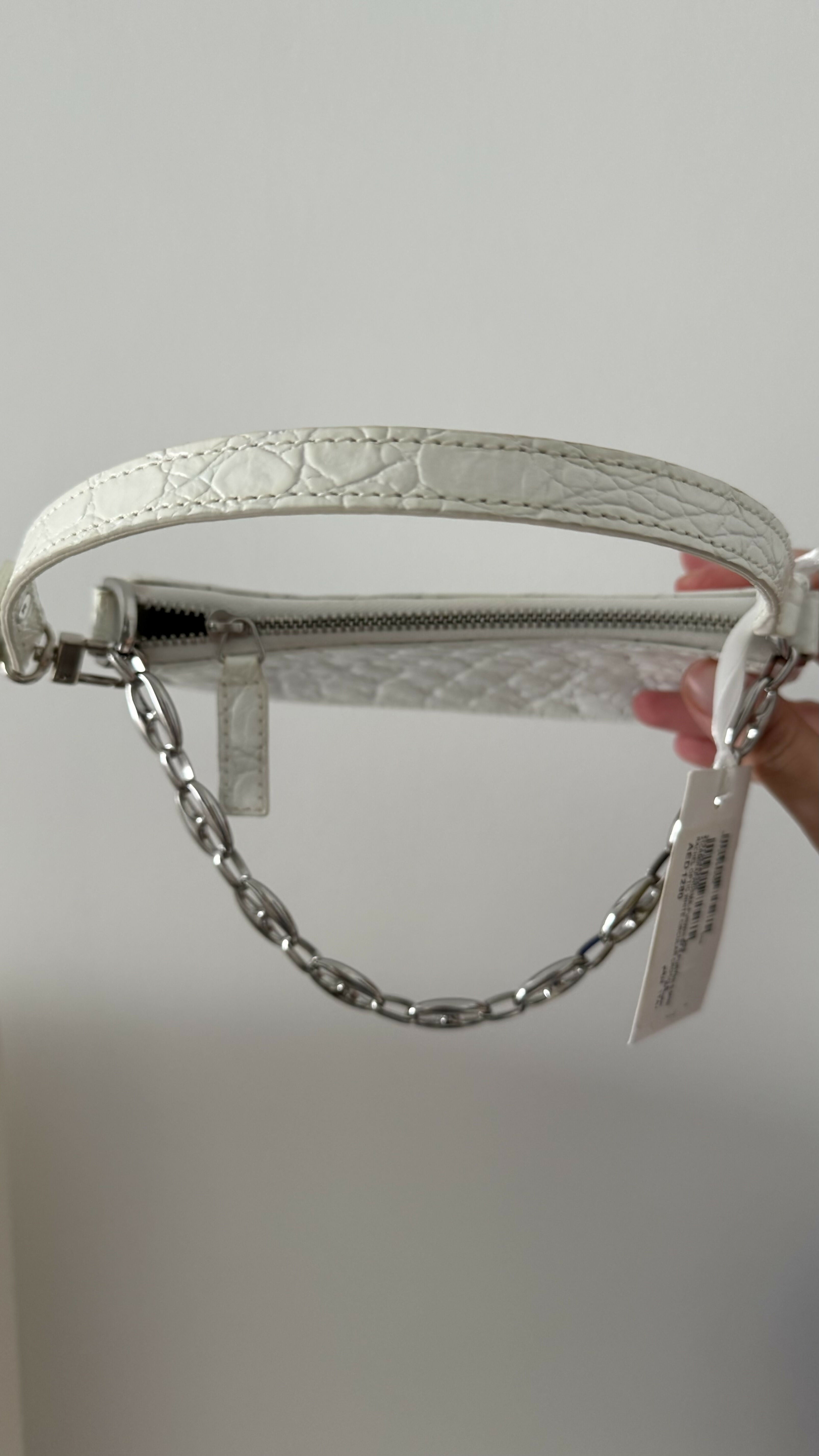 White quilted mini shoulder bag with silver hardware held up against neutral background — By Far | Endless UAE