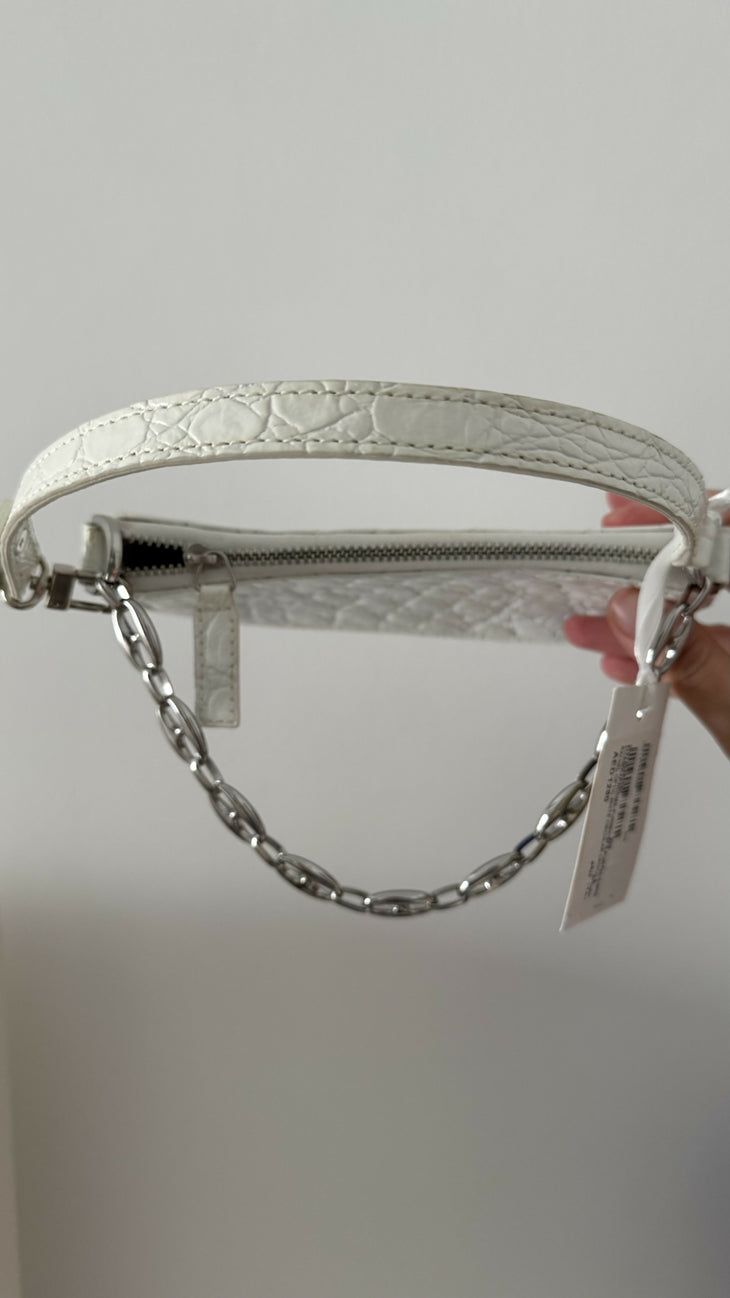 White quilted mini shoulder bag with silver hardware held up against neutral background — By Far | Endless UAE
