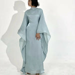 Woman wearing light blue flowing kaftan dress with draped sleeves against white background — Endless | Endless UAE