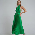 Woman wearing emerald green pleated halter maxi dress with cutout details and tan sandals — L'Idee | Endless UAE