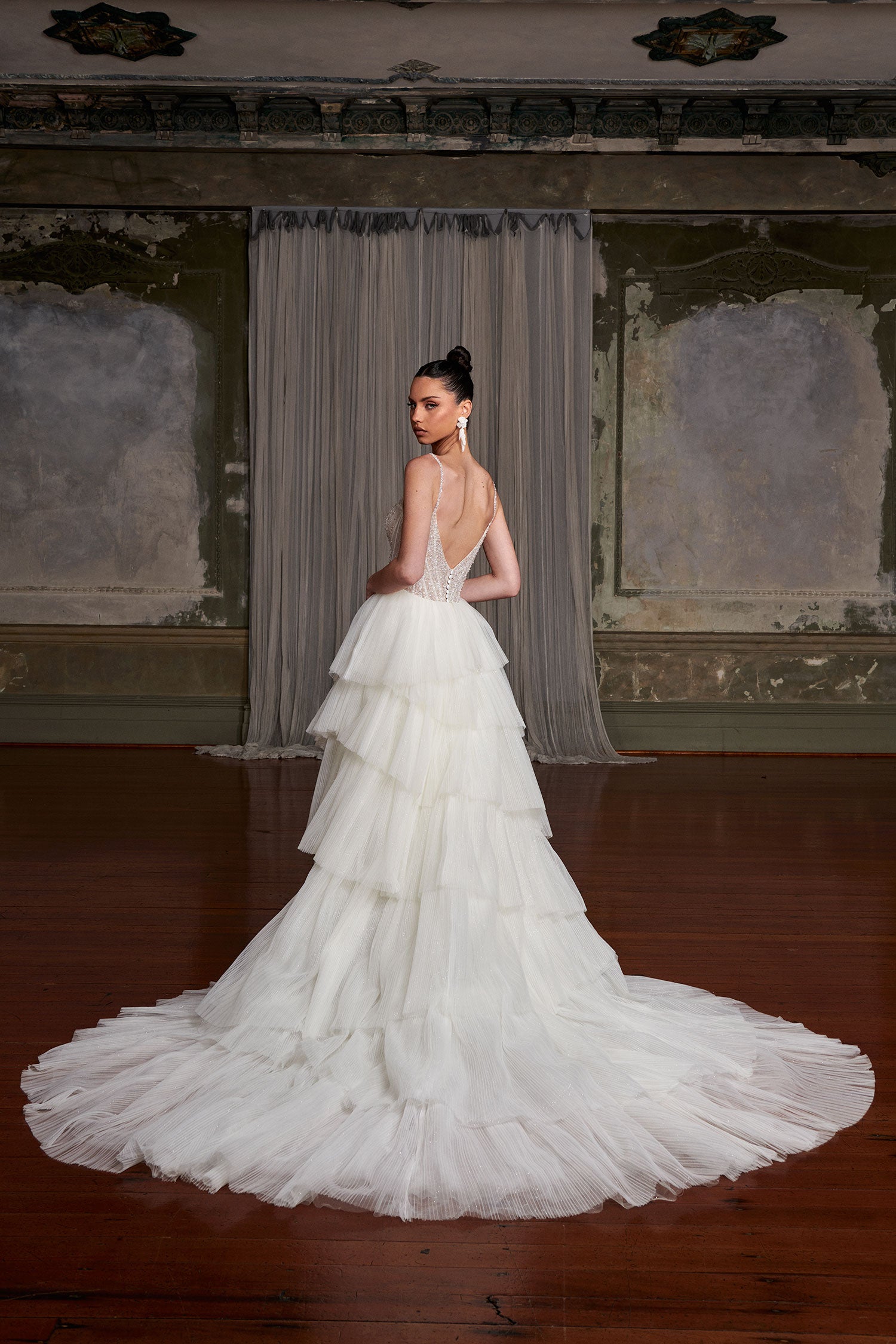 Elegant tiered tulle wedding gown with crystal-embellished bodice and dramatic train in vintage ballroom — You&I Bridal | Endless UAE