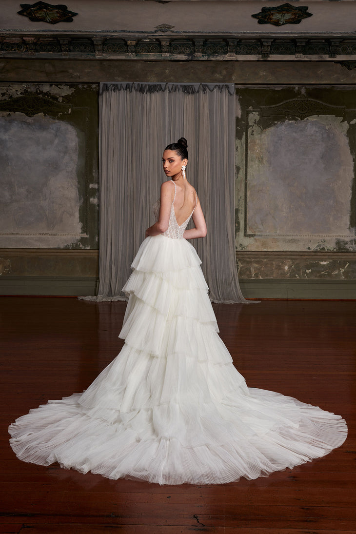 Elegant tiered tulle wedding gown with crystal-embellished bodice and dramatic train in vintage ballroom — You&I Bridal | Endless UAE