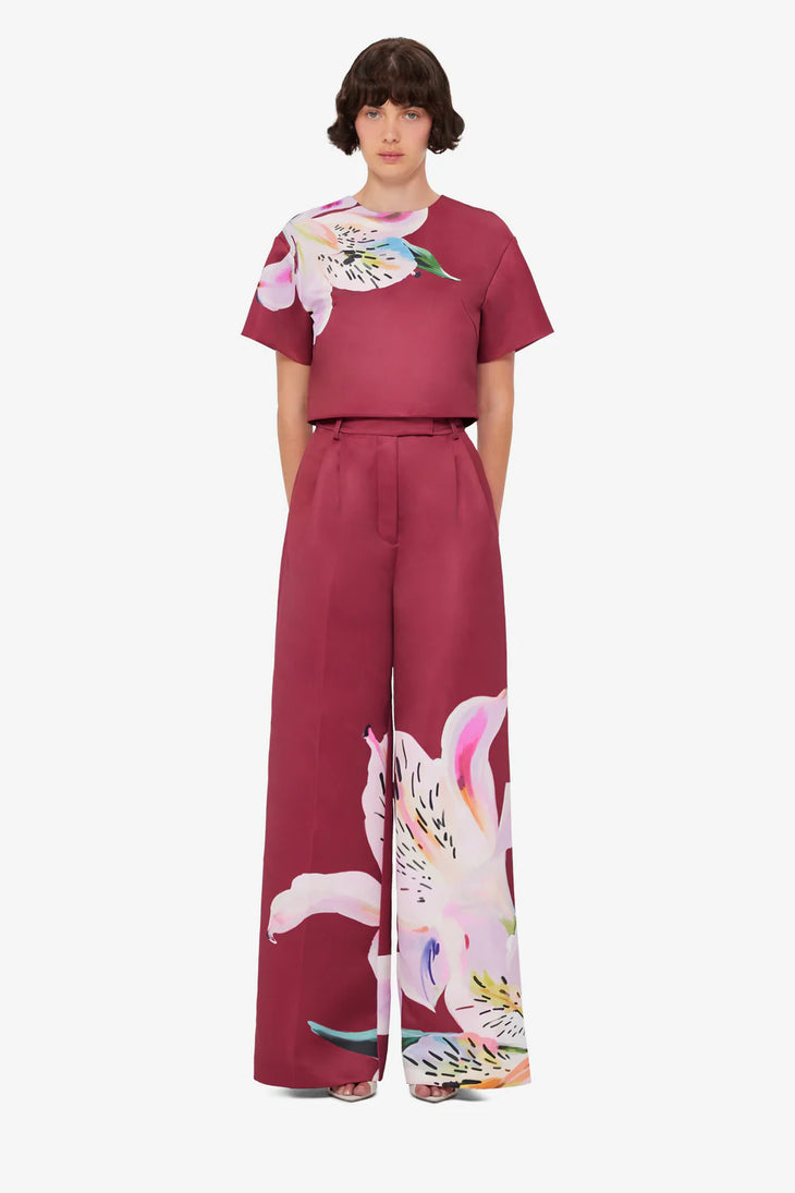Woman wearing burgundy crop top and wide-leg floral pants with colorful lily print — Leo Lin | Endless UAE