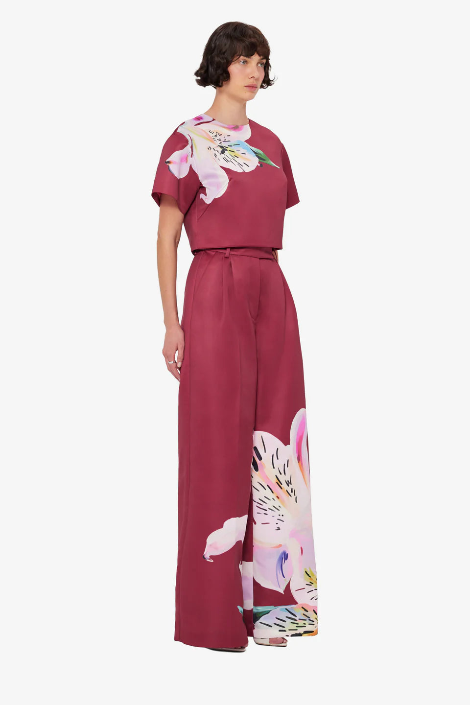 Woman wearing burgundy crop top and wide-leg floral pants with colorful lily print — Leo Lin | Endless UAE