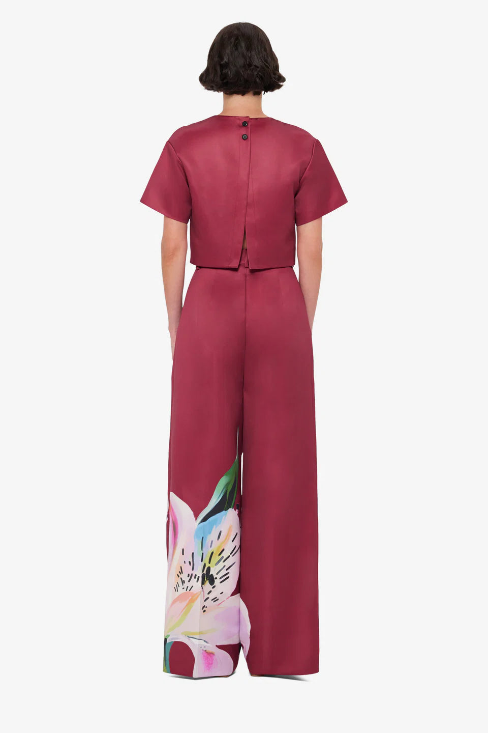 Woman wearing burgundy crop top and wide-leg floral pants with colorful lily print — Leo Lin | Endless UAE