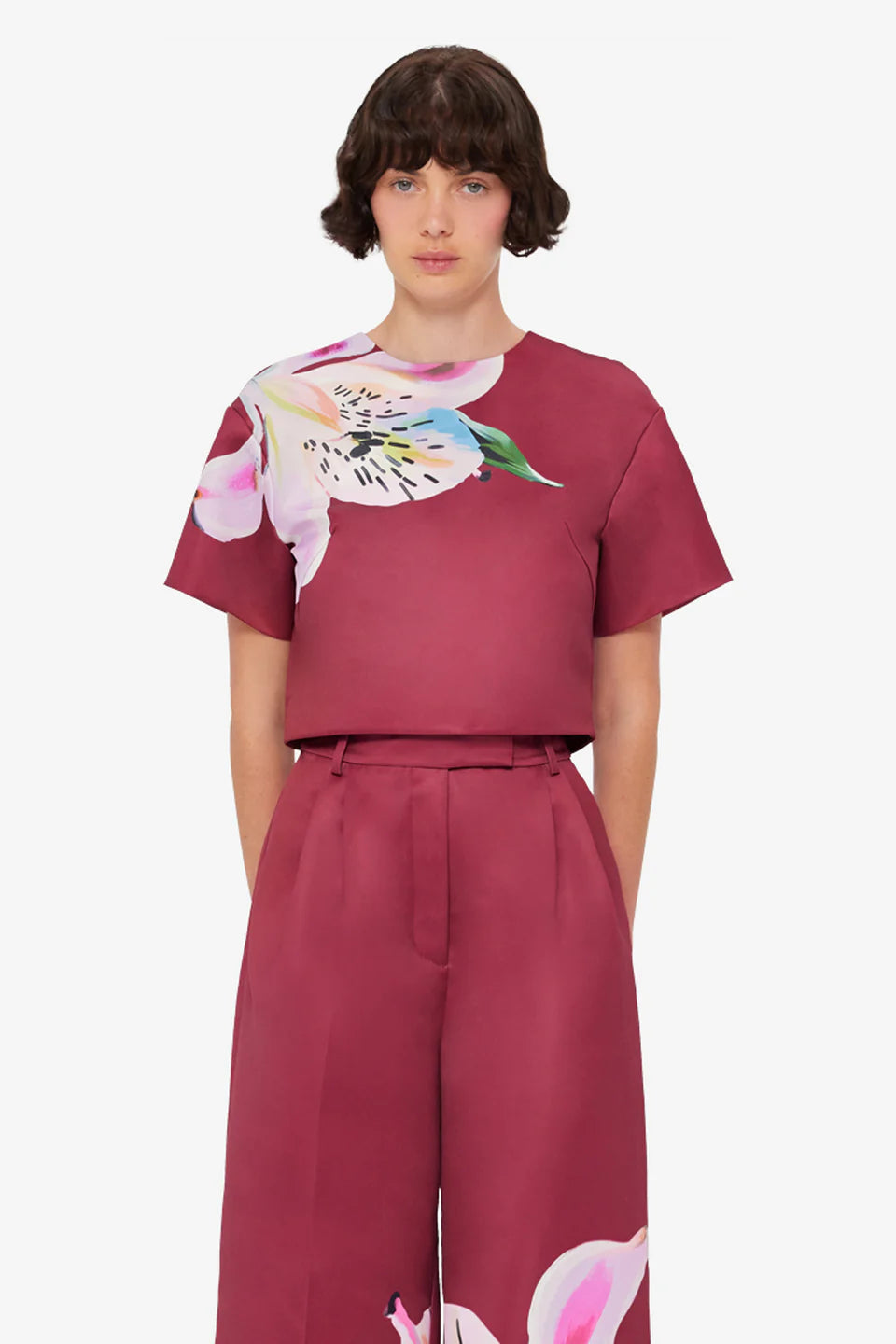 Woman wearing burgundy crop top and wide-leg floral pants with colorful lily print — Leo Lin | Endless UAE
