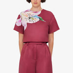 Woman wearing burgundy crop top and wide-leg floral pants with colorful lily print — Leo Lin | Endless UAE