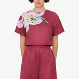 Woman wearing burgundy crop top and wide-leg floral pants with colorful lily print — Leo Lin | Endless UAE