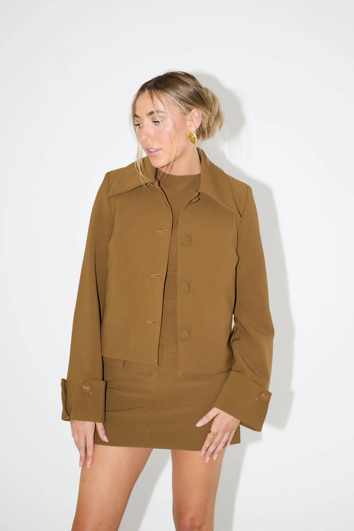 Woman wearing olive green mini skirt with matching blazer jacket in studio setting — Odd Muse | Endless UAE
