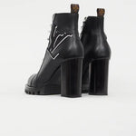 Black leather ankle boots with chunky heels, logo star detail, and pull tabs viewed from behind — Louis Vuitton | Endless UAE