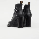 Black leather ankle boots with chunky heels, logo star detail, and pull tabs viewed from behind — Louis Vuitton | Endless UAE