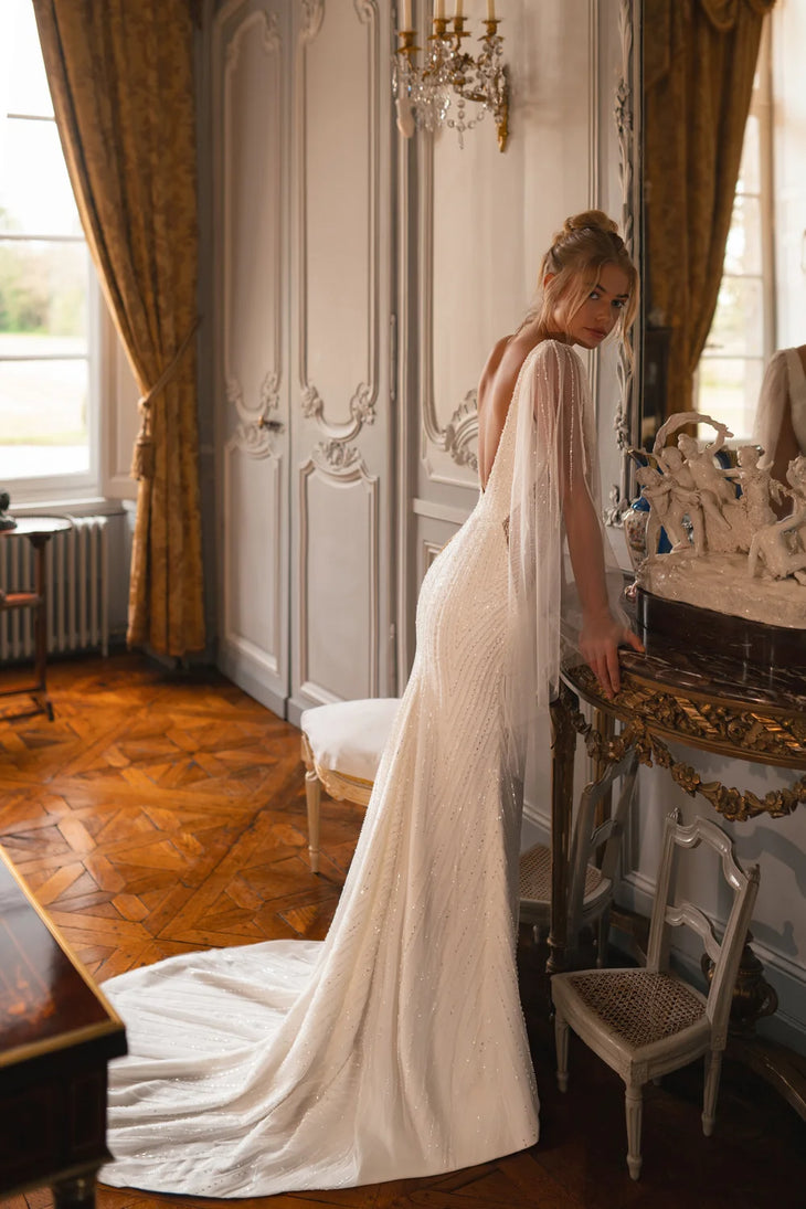 Embellished mermaid wedding dress with flowing cape and plunging neckline — Katy Corso Glen | Endless UAE