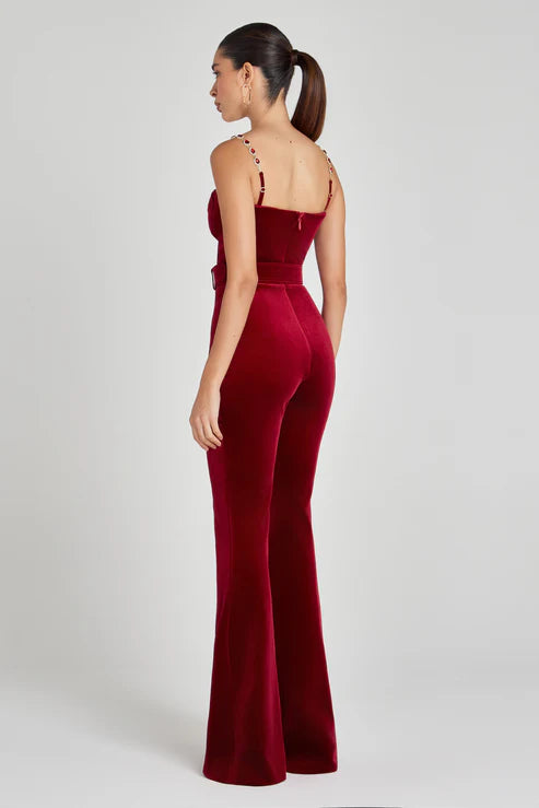 Rear view of woman wearing red fitted jumpsuit with embellished straps and flared legs — Nadine Merabi | Endless UAE