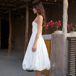 Woman in white tea-length bubble hem dress with spaghetti straps and white heels — Cleopatress | Endless UAE