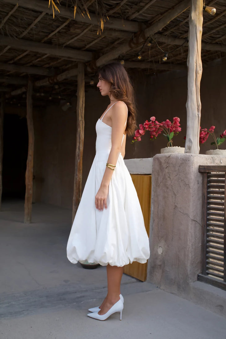Woman in white tea-length bubble hem dress with spaghetti straps and white heels — Cleopatress | Endless UAE