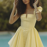 Woman wearing yellow off-shoulder mini dress with puffed sleeves by poolside — Endless | Endless UAE