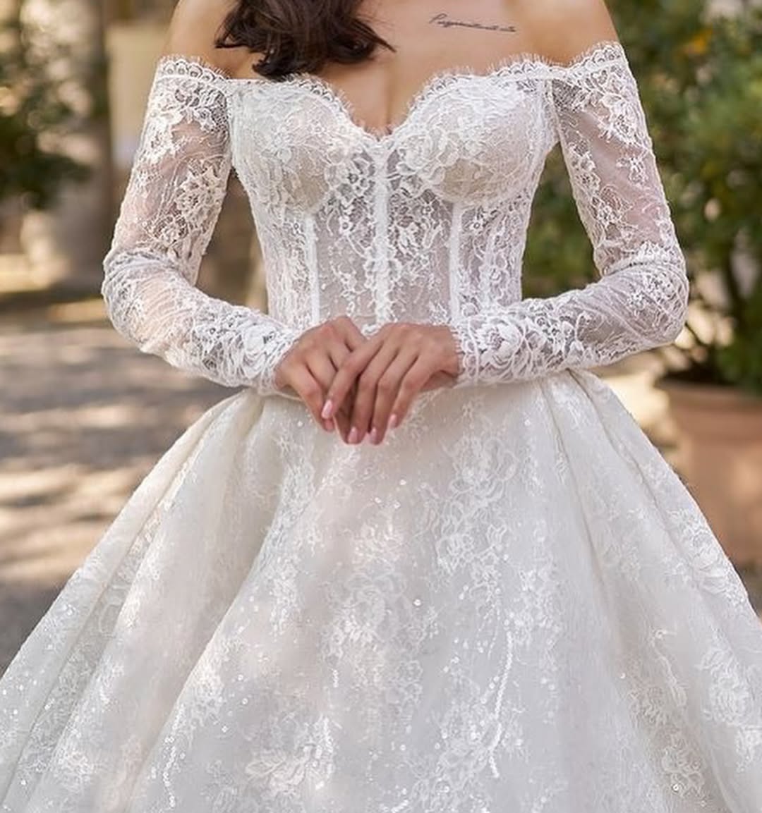 Elegant white lace off-shoulder ball gown wedding dress with long sleeves and sparkly tulle skirt — Sima Couture | Endless UAE