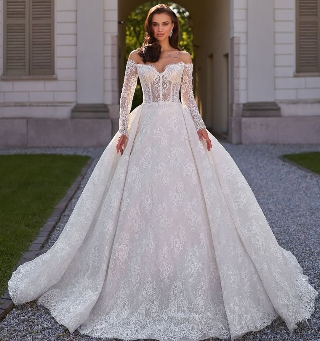 Elegant off-shoulder ball gown wedding dress with intricate lace detailing and long sleeves — Sima Couture | Endless UAE