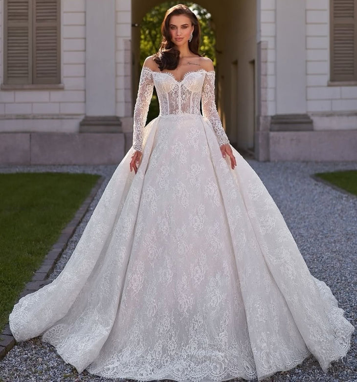 Elegant off-shoulder ball gown wedding dress with intricate lace detailing and long sleeves — Sima Couture | Endless UAE